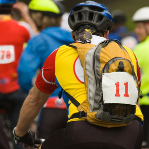 Bike racer from the back with race number on water backpack